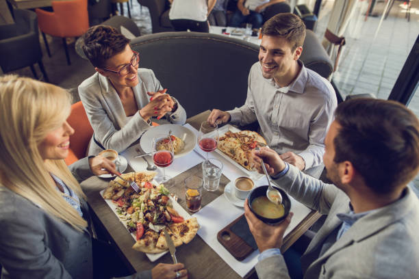 istock Young smiling business people communicating during lunch in rest 672324184