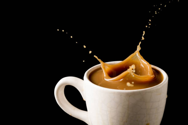 istock Cup of splashing coffee on black background 672325454