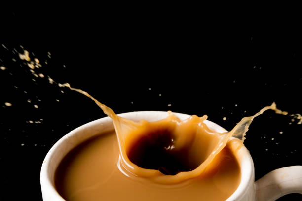 istock Cup of splashing coffee on black background 672325494