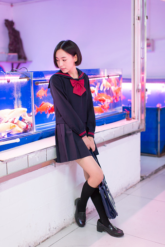 beautiful chinese female students wearing uniforms skirts, visiting the aquarium market