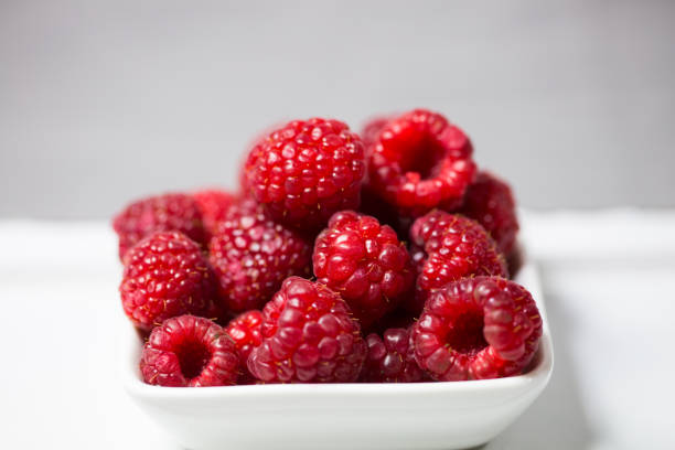 istock Raspberries in a bowl, gray background 672332848