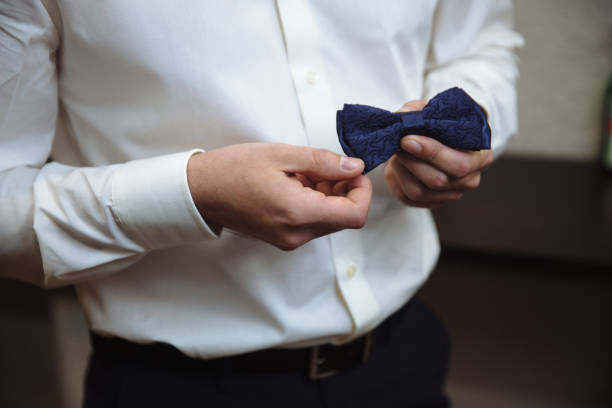 istock Man holding bow tie. Elegant gentleman clother. 672333238