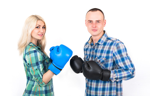 Studio shot of a beautiful funny couple expressive fighting on a white background.