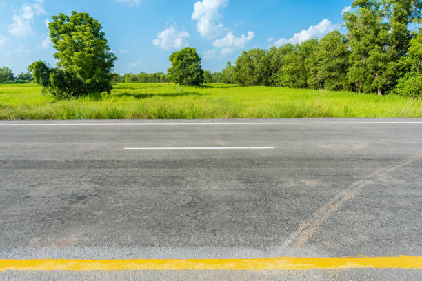 istock asphalt road and green rice field 672336338