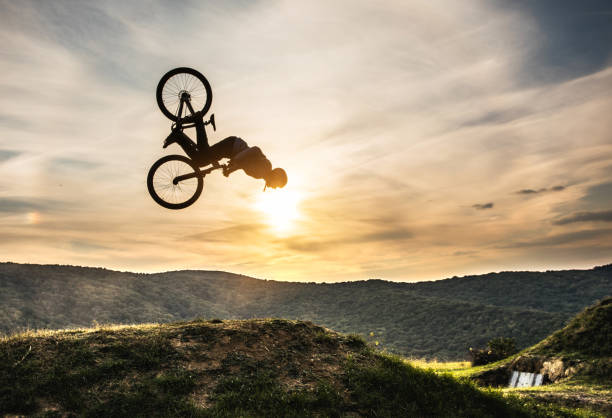 człowiek na rowerze robi backflip przed niebem o zachodzie słońca. - bmx cycling xtreme mountain bike sport zdjęcia i obrazy z banku zdjęć