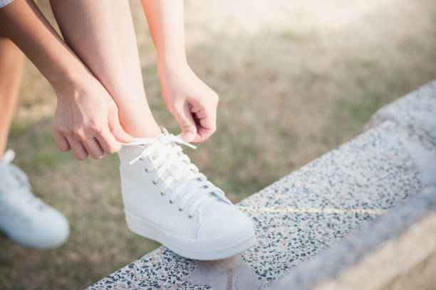 istock woman in white sneakers  walking under sunlight 672350176