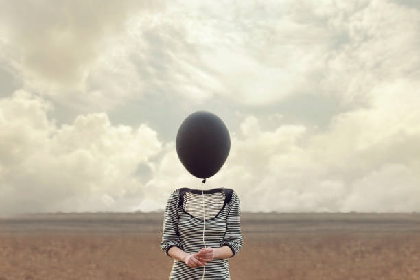 woman's head replaced by a black balloon - imagination fantasy invisible women imagens e fotografias de stock