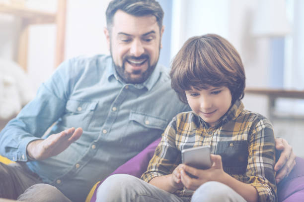 istock Father and son playing on smartphone 672350442