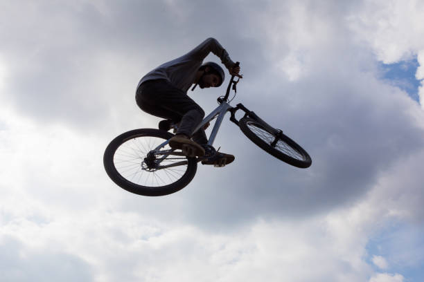 istock Below view of man on bicycle against the sky. 672351030