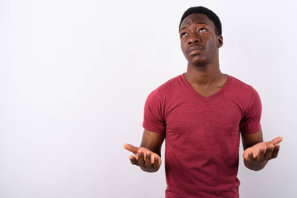 Studio shot of young muscular African man against white background Studio shot of young muscular African man against white background horizontal shot rolling eyes stock pictures, royalty-free photos & images