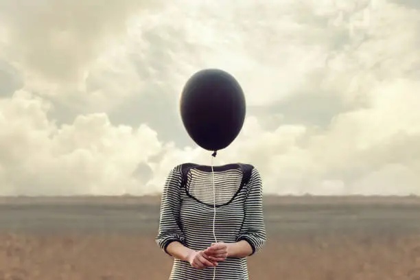 Photo of woman's head replaced by a black balloon
