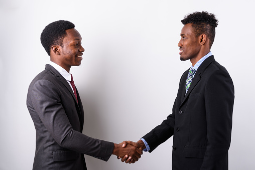 Studio shot of two young African businessmen against white background horizontal shot