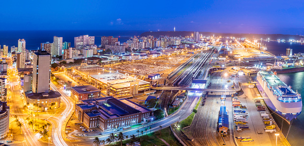 Durban city facing the indian ocean, a large port city where cargo ships drop off for delivery towards Johannesburg. Third largest after Johannesburg and Cape Town, and rapid development towards the north, with corporate international companies. Container cargo ships seen unloading at the harbour.