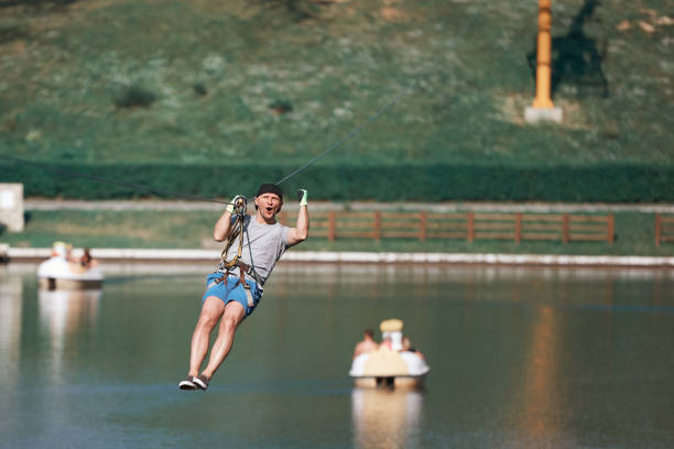 feche o forro sobre o lago - zip lining - fotografias e filmes do acervo