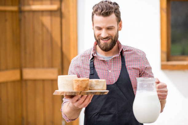 istock Farmer with milk and cheese outdoors 672369072