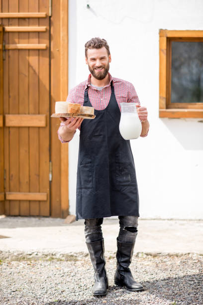 istock Farmer with milk and cheese outdoors 672369152