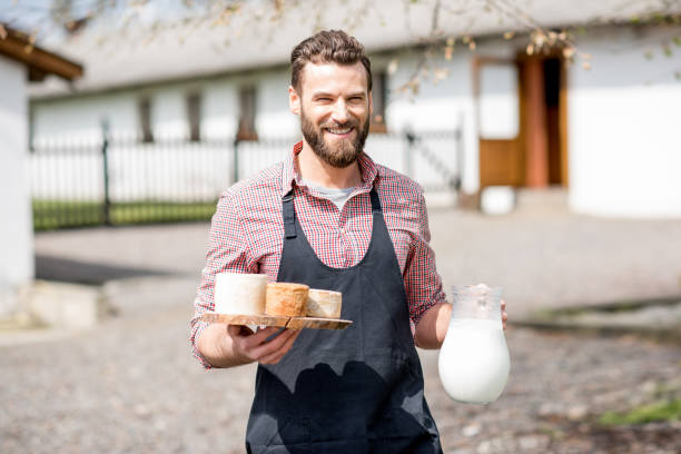 istock Farmer with milk and cheese outdoors 672369238