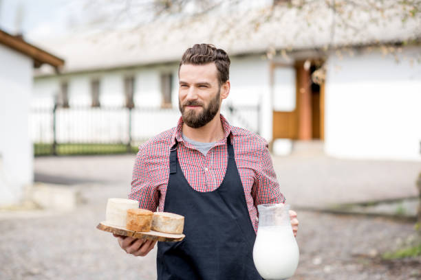 istock Farmer with milk and cheese outdoors 672369404