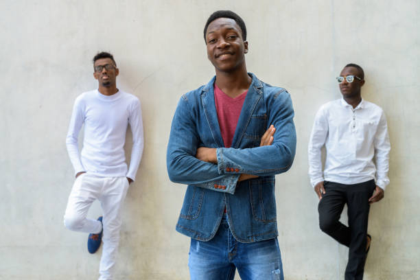 istock Group of three young African men against gray concrete wall 672369418