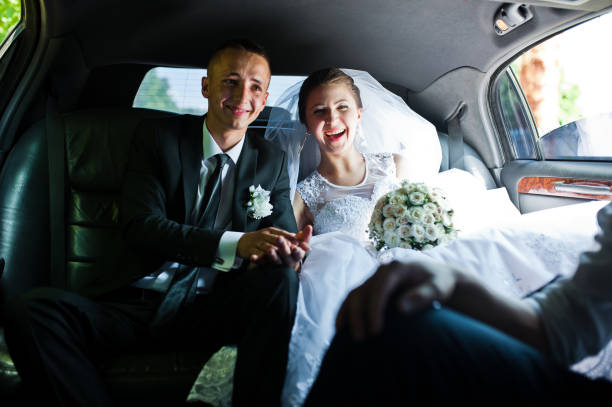 istock happy wedding couple sitting in limo 672377180