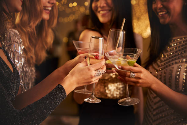 weibliche freunde machen toast, wie sie feiern bei party - cocktail stock-fotos und bilder