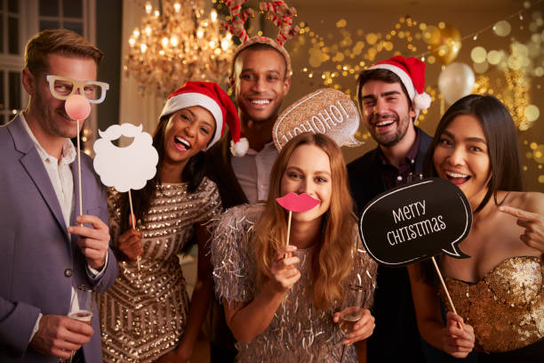 Group Of Friends Dressing Up For Christmas Party Together Group Of Friends Dressing Up For Christmas Party Together photo booth stock pictures, royalty-free photos & images