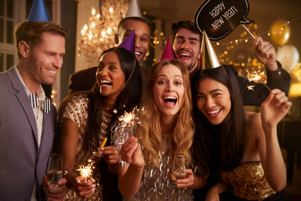 Group Of Friends Celebrating At New Year Party Together Group Of Friends Celebrating At New Year Party Together new years eve parties stock pictures, royalty-free photos & images