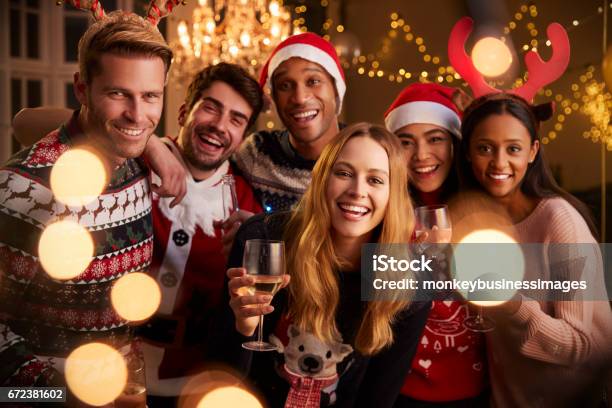 Portret Van Vrienden In Feestelijke Truien Op Christmas Party Stockfoto en meer beelden van Kerstmis