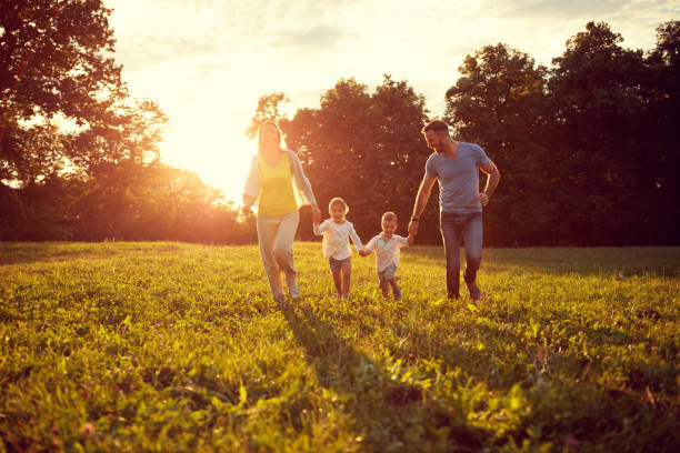 istock Happy children with parents running in park 672381960