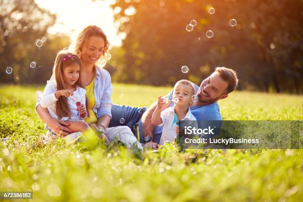 Children Enjoying In Making Soap Bubbles Stock Photo - Download Image Now - Family, Springtime, Picnic