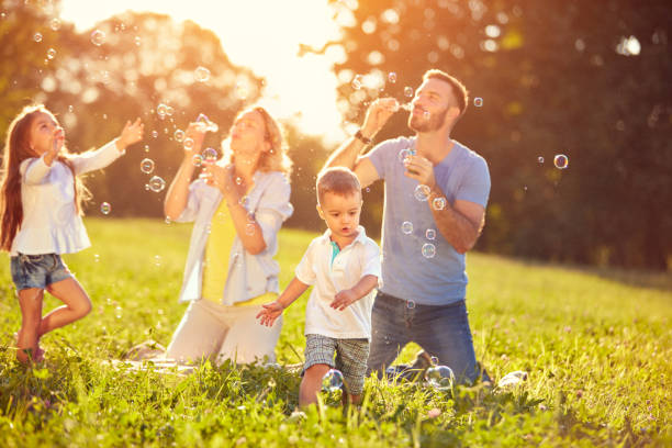 istock Happy children enjoying in chasing soap bubbles 672386734