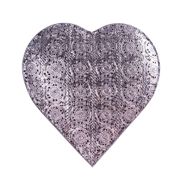 istock A pierced, silver, heart-shaped ornament isolated on white 672387232