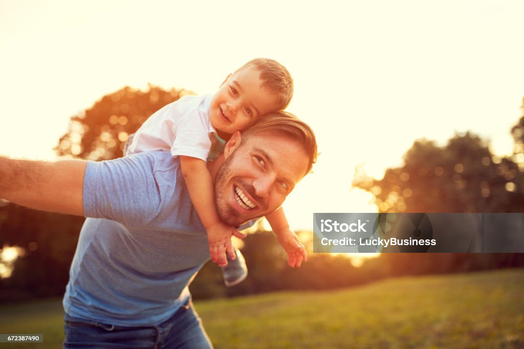 Father piggyback his son outside Father piggyback his little son outside Father Stock Photo