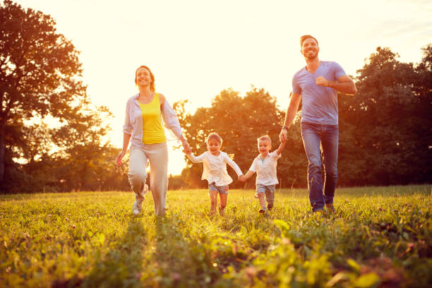 istock Happy family run on green field 672387694