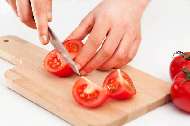 istock Woman hands cutting tomato 672390322