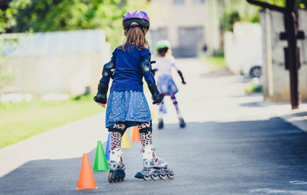 istock Children learning to roller skate on the road with cones. 672391596