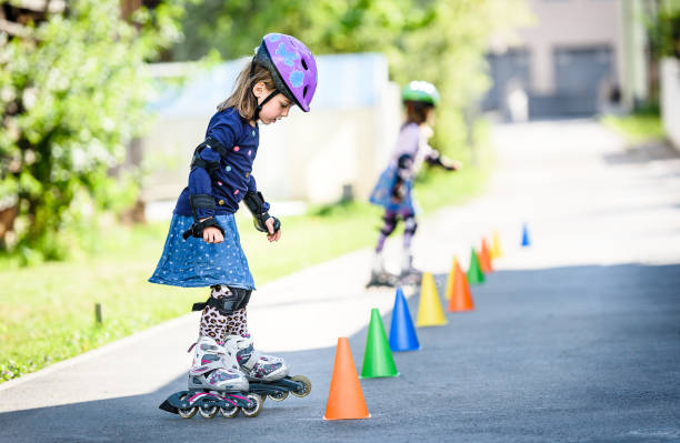 istock Children learning to roller skate on the road with cones. 672394112
