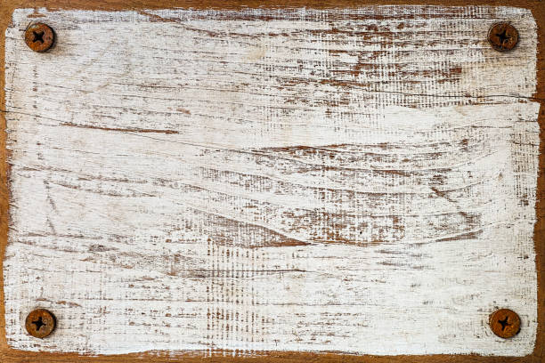 istock Distressed white wooden grained panel background with four screws, one in each corner. 672398288