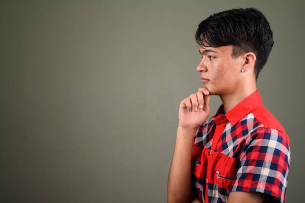 Studio shot of young Asian man against colored background horizontal shot