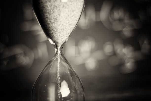 istock Hourglass on wood with a blackboard background 672403128