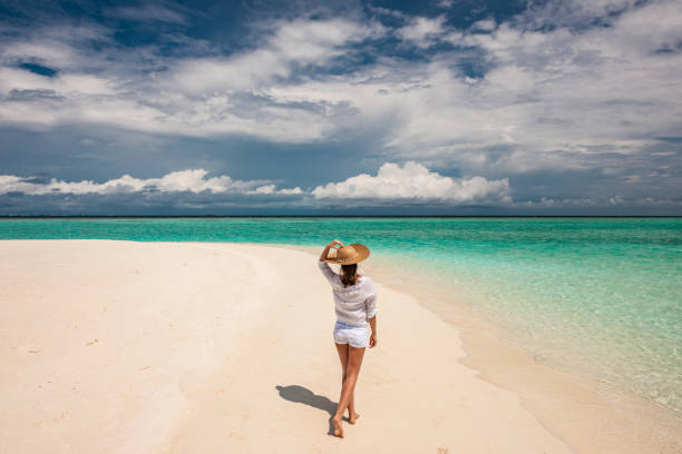 istock Woman with sun hat on tropical beach 672405570
