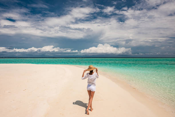 istock Woman with sun hat on tropical beach 672405576