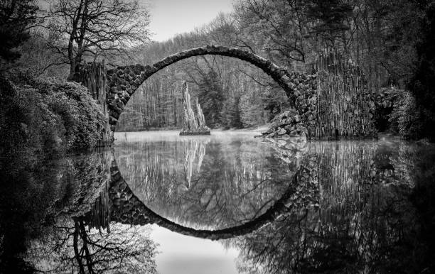 rakotz bridge in kromlau - spring forest scenics reflection imagens e fotografias de stock