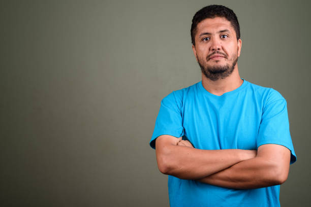 Studio shot of mature Persian man against colored background horizontal shot