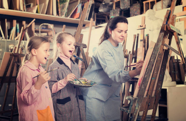 istock Smiling woman giving master class during drawing 672411804