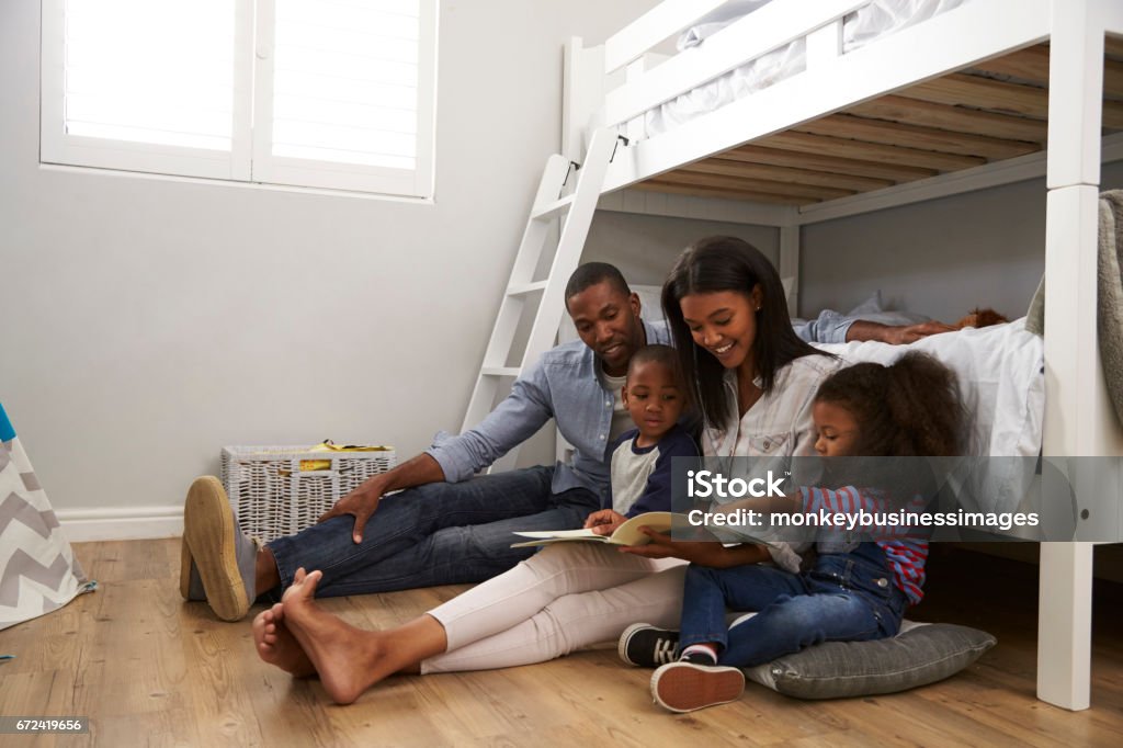 Parents Reading Story To Children In Their Bedroom Family Stock Photo