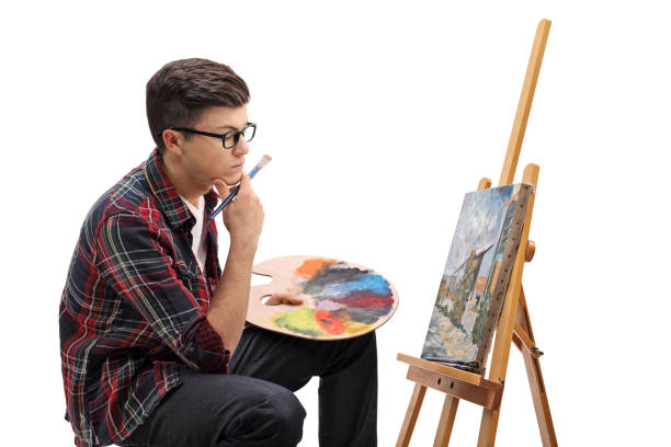 istock Pensive teenage painter looking at a painting 672421864