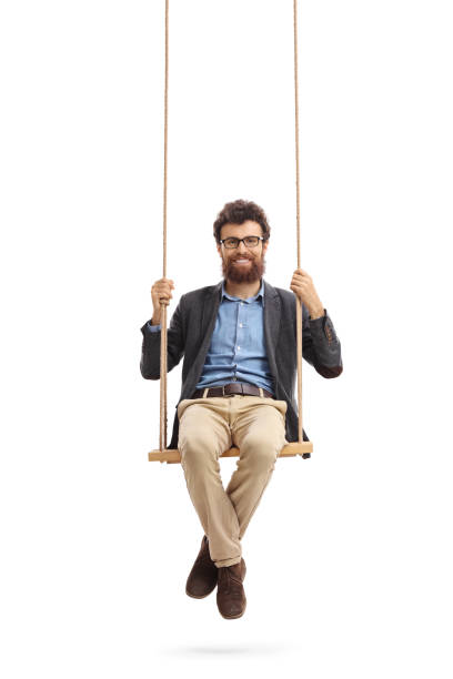 istock Bearded man sitting on a swing and looking at the camera 672422042