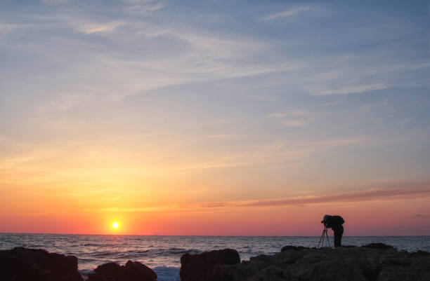 istock Silhouette of a photographer with a backpack at sunset 672422188