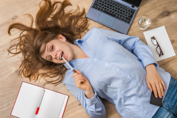 istock Smiling woman lying on back with laptop and smartphone 672425874